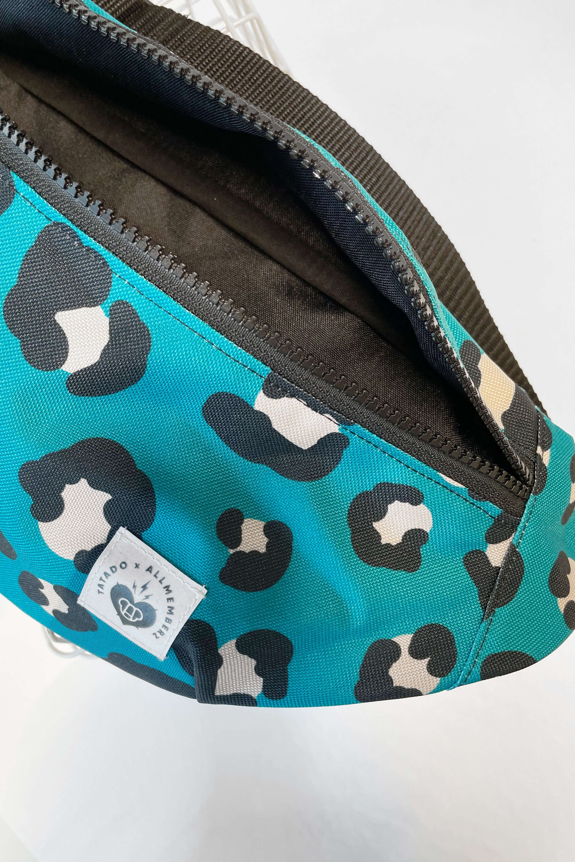 sac banane pour enfant et adulte motif léopard coloré fond bleu vert, vue en gros plan